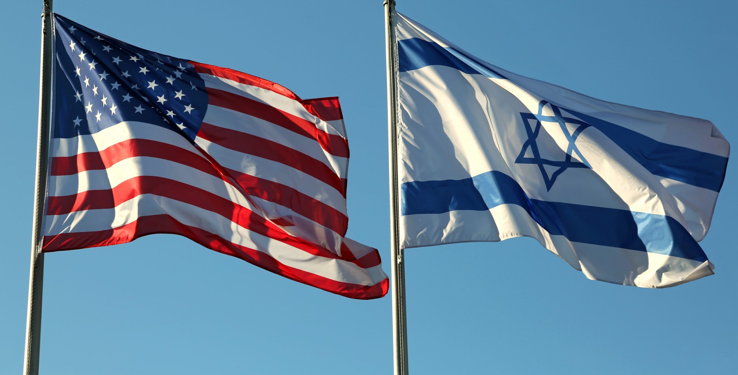 two flags: American and Israeli waving in the blue sky