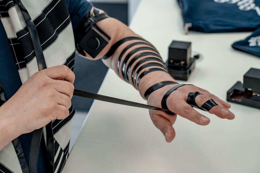 Man wrapping tefillin around his palm, after putting around his fingers, the final step in the process of putting on tefillin.