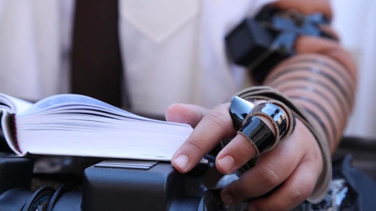 Jewish man with tefillin close up on his left hand