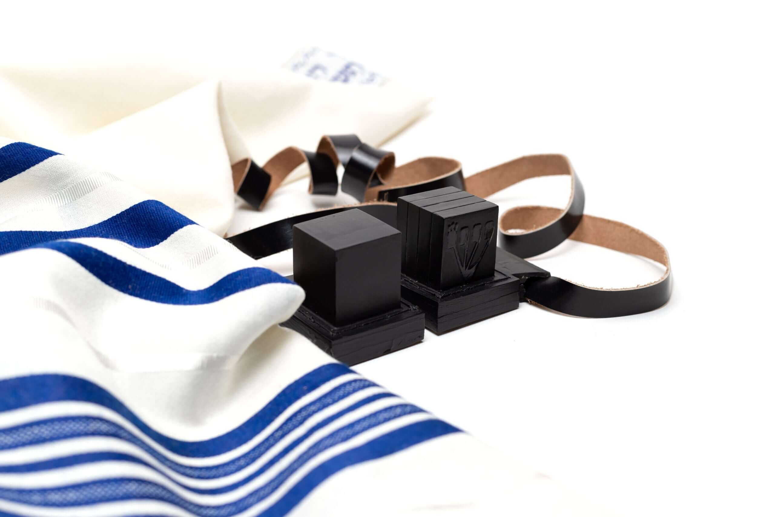 Centered is a pair of Tefillin and blue and white tallit on the left side
